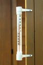 Outdoor thermometer hanging on a brown wooden wall closeup