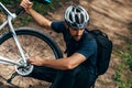 Outdoor top view of professional handsome cyclist man fixing a bicycle brake during riding the bike on the mountain