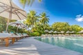 Luxury poolside with beach background, beach chair around swimming pool in hotel resort with sea beach background, holiday Royalty Free Stock Photo