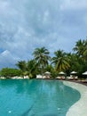 Outdoor tourism landscape. Luxurious beach resort with swimming pool palm trees and blue sky. Royalty Free Stock Photo