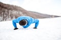 Outdoor training with athlete doing push ups on snow