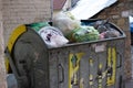 Outdoor trash bin with food waste. Not sorted garbage, yard, stench, filth