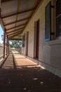 Outdoor verandah patio deck of sandstone brick cottage with picket fence in sunshine with trees in background Royalty Free Stock Photo