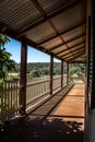 Outdoor verandah patio deck of sandstone brick cottage with picket fence in sunshine with trees in background Royalty Free Stock Photo