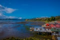 Outdoor view of beautiful coorful wooden houses on stilts palafitos, in a low tide day view in gorgeous sunny day in