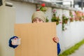 Outdoor view of homeless woman holding up blank cardboard sign Royalty Free Stock Photo