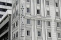 Outdoor view of Hotel sign of building with windows with curtain on white wall Royalty Free Stock Photo