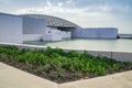 Angled view of Louvre Abu Dhabi Museum with garden in Abu Dhabi, U.A.E.