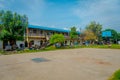 Outdoor view of many goats resting and walking in a green area surrounding of houses in the town close to Tashi refugee