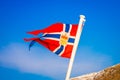 Outdoor view of Norwegian flag waving with a beautiful blue sky background Royalty Free Stock Photo