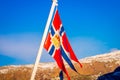 Outdoor view of Norwegian flag waving with a beautiful blue sky background Royalty Free Stock Photo