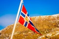 Outdoor view of Norwegian flag waving with a beautiful blue sky background Royalty Free Stock Photo