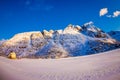 Outdoor view of white wooden house covered with snow and huge mountaing behind in snowy winter in the Arctic Circle Royalty Free Stock Photo