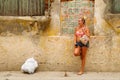 Outdoor view of young beautiful woman posing in front of damaged house in Santa Marta, Colombia