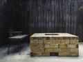 An outdoor vintage brick fireplace with bench on wood plank wall background Royalty Free Stock Photo