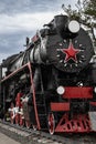 Vintage exhibit, Black Locomotive with red wheels red star. soviet steam locomotive on rails