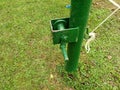 Outdoor volleyball net pole painted green with net pulley and hoist