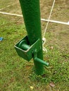 Outdoor volleyball net pole painted green with net pulley and hoist