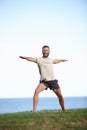 Outdoor warrior. Full length shot of a handsome mature man doing yoga outdoors. Royalty Free Stock Photo