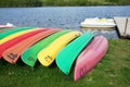 A row of colorful kayaks canoes along a lake in France