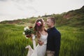 Outdoor wedding ceremony, stylish happy smiling groom and bride are hugging and looking at each other. The moment before kiss Royalty Free Stock Photo