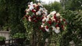 Outdoor wedding decor showcases elegant floral arrangements with roses, greenery on aisle, romantic setting for nuptials