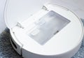Outdoor white robot vacuum Cleaner, dust collection container. Home cleaning, technology, smart home