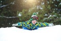 Boy sledding in a snowy forest. Outdoor winter fun for Christmas vacation. Royalty Free Stock Photo