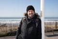 Outdoor winter portrait of beard middle age man handsome with wool hat in sea beach coast Royalty Free Stock Photo