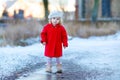 Outdoor winter portrait of little cute toddler girl in red coat and white fashion hat barret. Healthy happy baby child Royalty Free Stock Photo