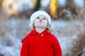 Outdoor winter portrait of little cute toddler girl in red coat and white fashion hat barret. Healthy happy baby child Royalty Free Stock Photo