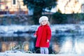 Outdoor winter portrait of little cute toddler girl in red coat and white fashion hat barret. Healthy happy baby child Royalty Free Stock Photo