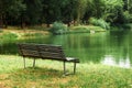 Outdoor wood chair in garden with pond, empty bench in park Royalty Free Stock Photo