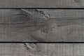 Outdoor wooden flooring from the planks. Knots, scratches and black lines between the boards. Texture for background