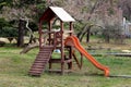 Outdoor wooden public playground equipment with climbing steps and slide
