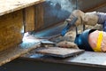 Outdoor worker with protective mask welding metal and sparks