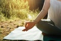 Outdoor yoga and meditation. Close-up of woman sitting on the beach on yoga mat in lotus position. Royalty Free Stock Photo