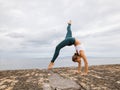 Outdoor yoga practice near the ocean. Caucasian woman practicing Adho Mukha Vrksasana. Yoga Handstand is an inverted asana. Royalty Free Stock Photo