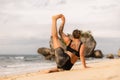 Outdoor yoga practice near the ocean. Caucasian woman practicing Eka Pada Sirsasana, Foot-behind-the-Head Pose. Flexible healthy Royalty Free Stock Photo