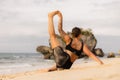 Outdoor yoga practice near the ocean. Caucasian woman practicing Eka Pada Sirsasana, Foot-behind-the-Head Pose. Flexible healthy Royalty Free Stock Photo