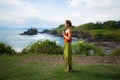 Outdoor yoga practice. Young woman standing on the grass. Hands in namaste mudra, closed eyes. Tanah Lot temple, Bali Royalty Free Stock Photo