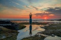 Outdoor yoga practice. Young woman standing on the rock. Hands in namaste mudra. Amazing water reflection. Tanah Lot temple, Bali