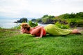 Outdoor yoga practice. Young woman practicing Ashtanga Namaskara, Eight limbed pose as part of the Sun Salutation series of asanas