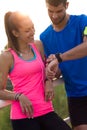 Outdoor young couple using they smartwatch after running. Royalty Free Stock Photo