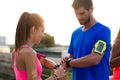 Outdoor young couple using they smartwatch after running. Royalty Free Stock Photo