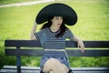 Outdoor, young girl with big black pigeon sitting on a wooden be Royalty Free Stock Photo