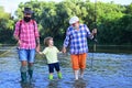 Outdoors active lifestyle. Grandfather with son and grandson having fun in river. Happy fathers day. Fishing. Summer day Royalty Free Stock Photo