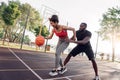 Outdoors Activity. African couple girl dribbling happy while guy defencing backdoor touching her waist blocking on Royalty Free Stock Photo