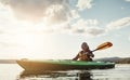 An outdoors activity with a little exercise involved. a young woman kayaking on a lake.