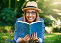 The outdoors is the best place to read. Portrait of an attractive young woman reading a book while lying outside on the Royalty Free Stock Photo